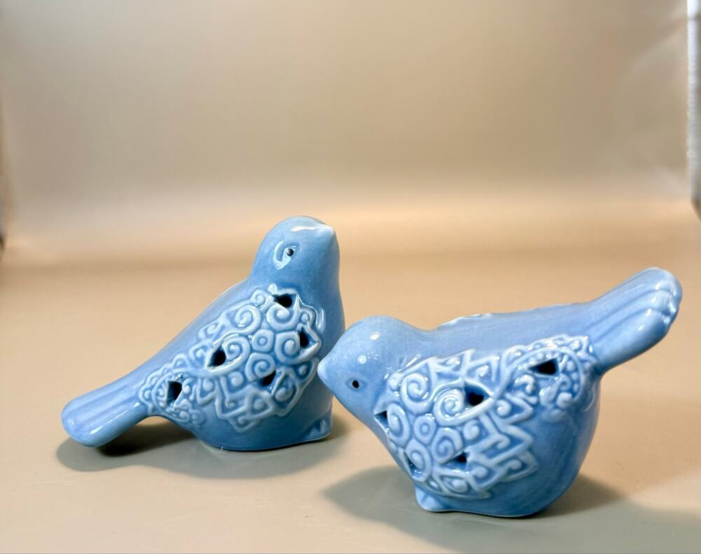 light blue glazed ceramic bird figurines with an intricate, open-work lattice.